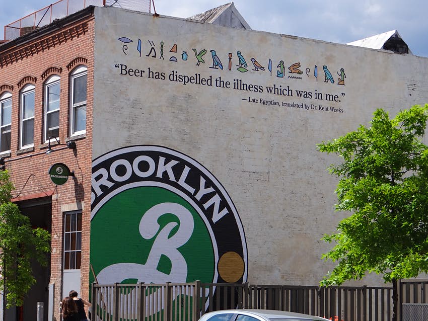 A green Brooklyn Brewery logo is plastered on the side of brick building.